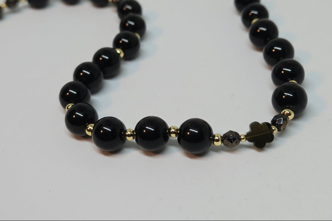 Golden Obisdian bracelet / Tasbeeh / Misbaha with gold accents, czech crystals, obisdan clover charm on light grey background.